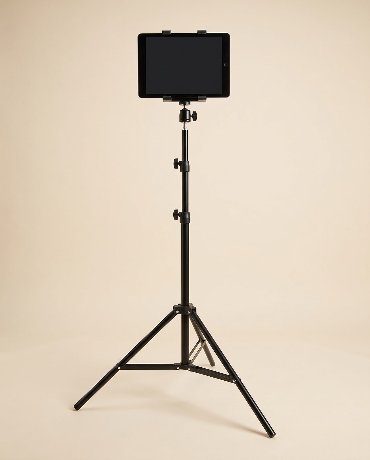 Black tablet floor stand with tripod legs, ball head and tablet clamp holding a tablet