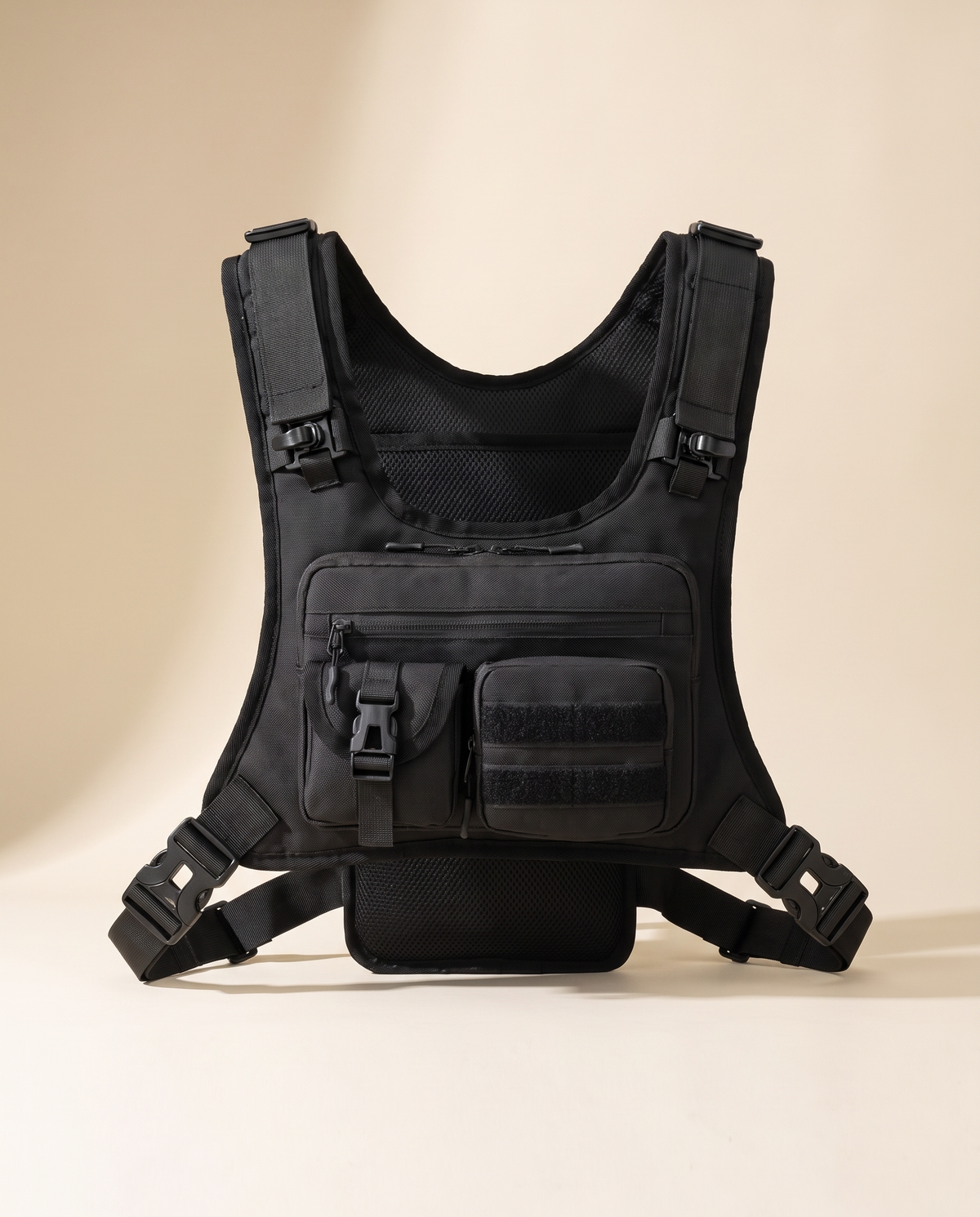 Black tactical chest rig, front view, showing the zipped chest pocket, buckled pouch and quick-release side straps
