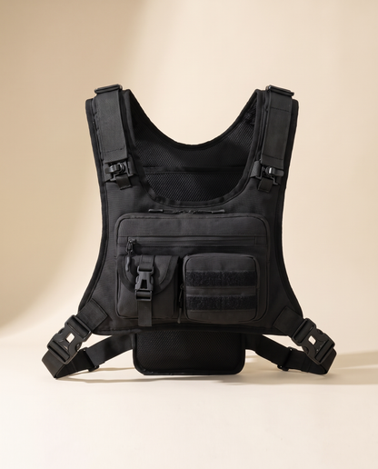 Black tactical chest rig, front view, showing the zipped chest pocket, buckled pouch and quick-release side straps